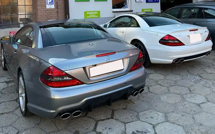 Srebrny i biały Mercedes zaparkowane przed warsztatem Auto Serwis VIVA.