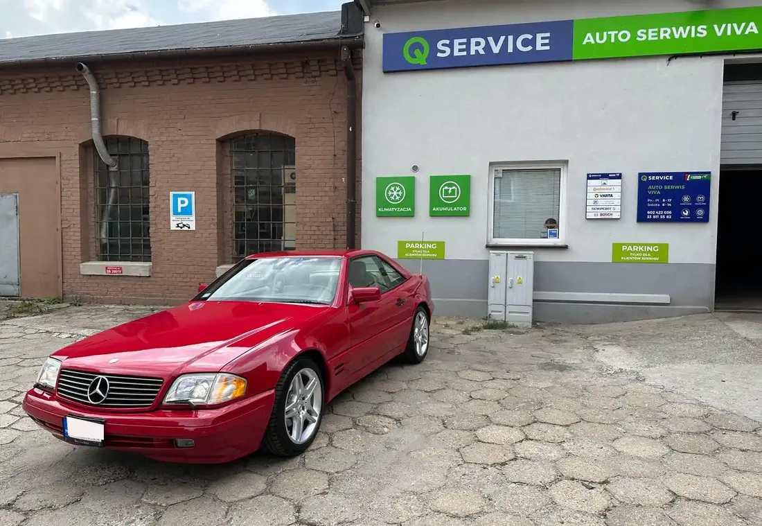 Budynek Auto Serwis VIVA z szyldem Q Service i czerwonym Mercedesem przed wejściem.
