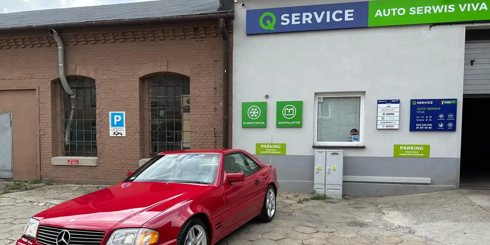 Budynek Auto Serwis VIVA z szyldem Q Service i czerwonym Mercedesem przed wejściem.